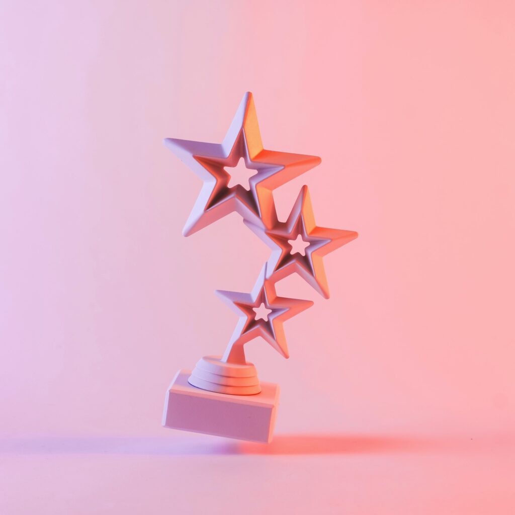 Award with three star shapes floating against pink background