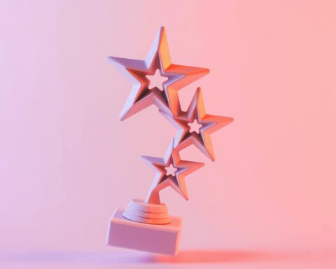 Award with three star shapes floating against pink background